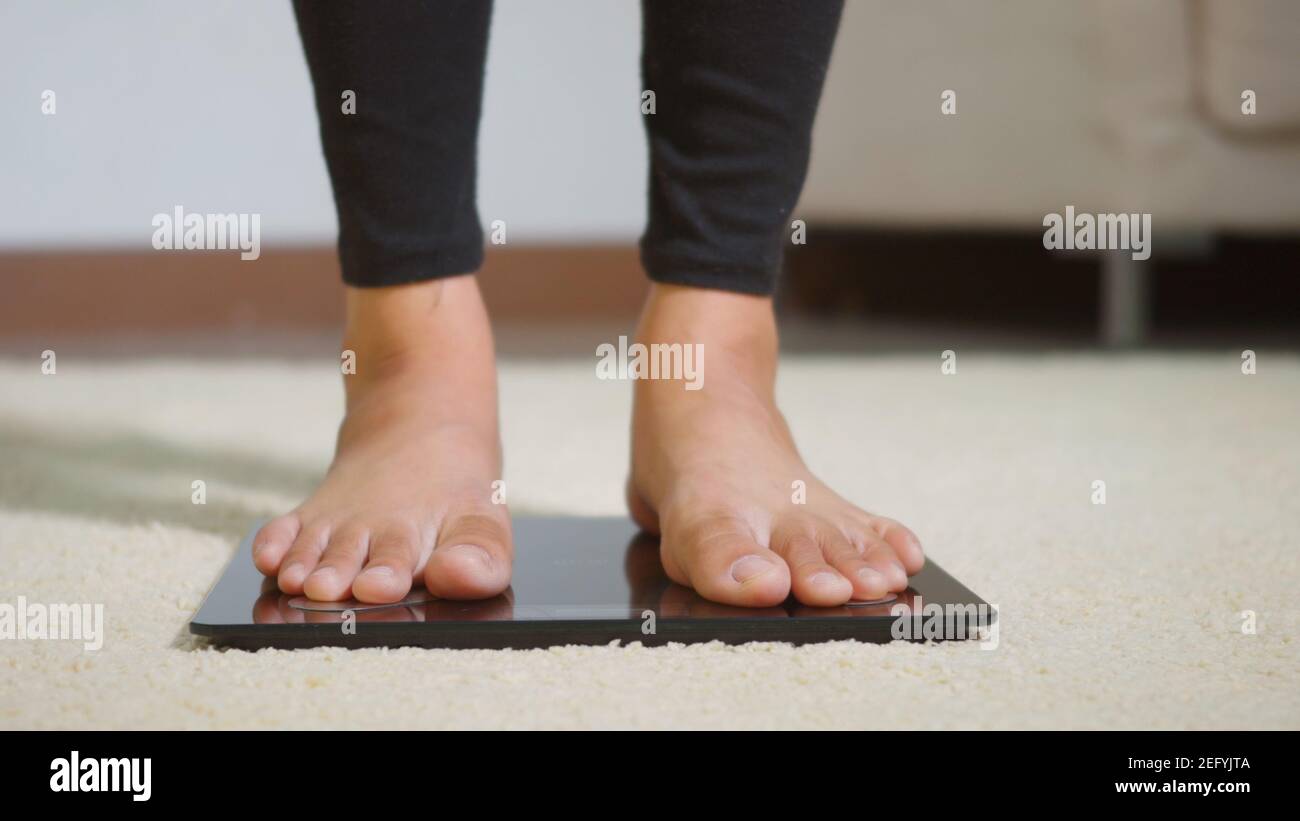 https://c8.alamy.com/comp/2EFYJTA/asian-young-woman-leg-stepping-standing-on-floor-electric-scales-female-working-out-at-home-in-living-room-female-stand-on-digital-weighing-machine-2EFYJTA.jpg