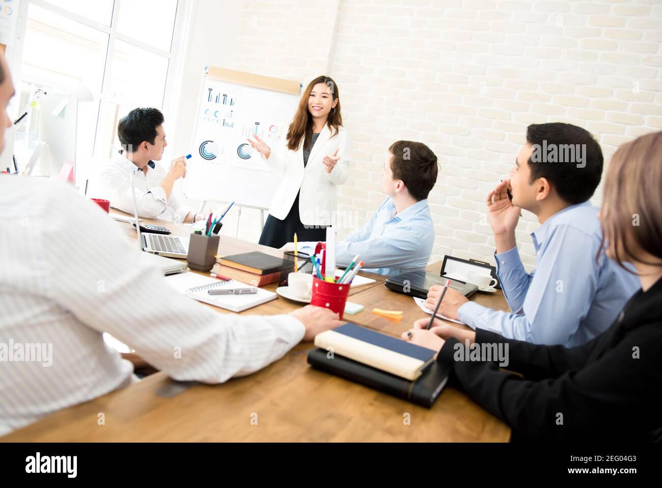 Asian business woman leader presenting work to mixed race colleagues in the meeting Stock Photo