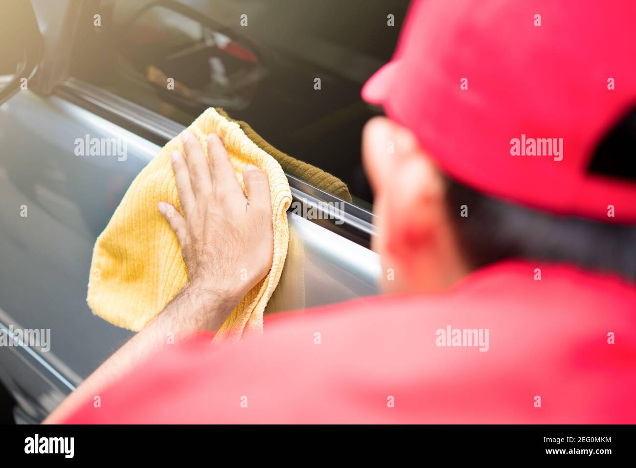 Auto service staff cleaning car door with microfiber cloth Stock Photo