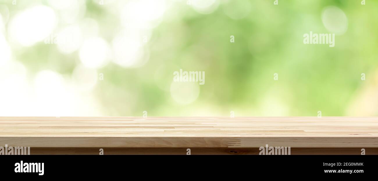 Wood table top on  blur abstract natural green background, panoramic banner - can be used for display or montage your products Stock Photo