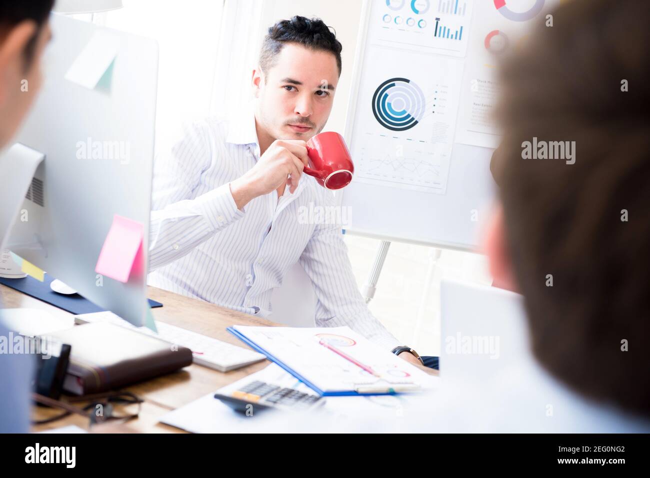 Casual businessman drinking coffee at his working table in the office Stock Photo