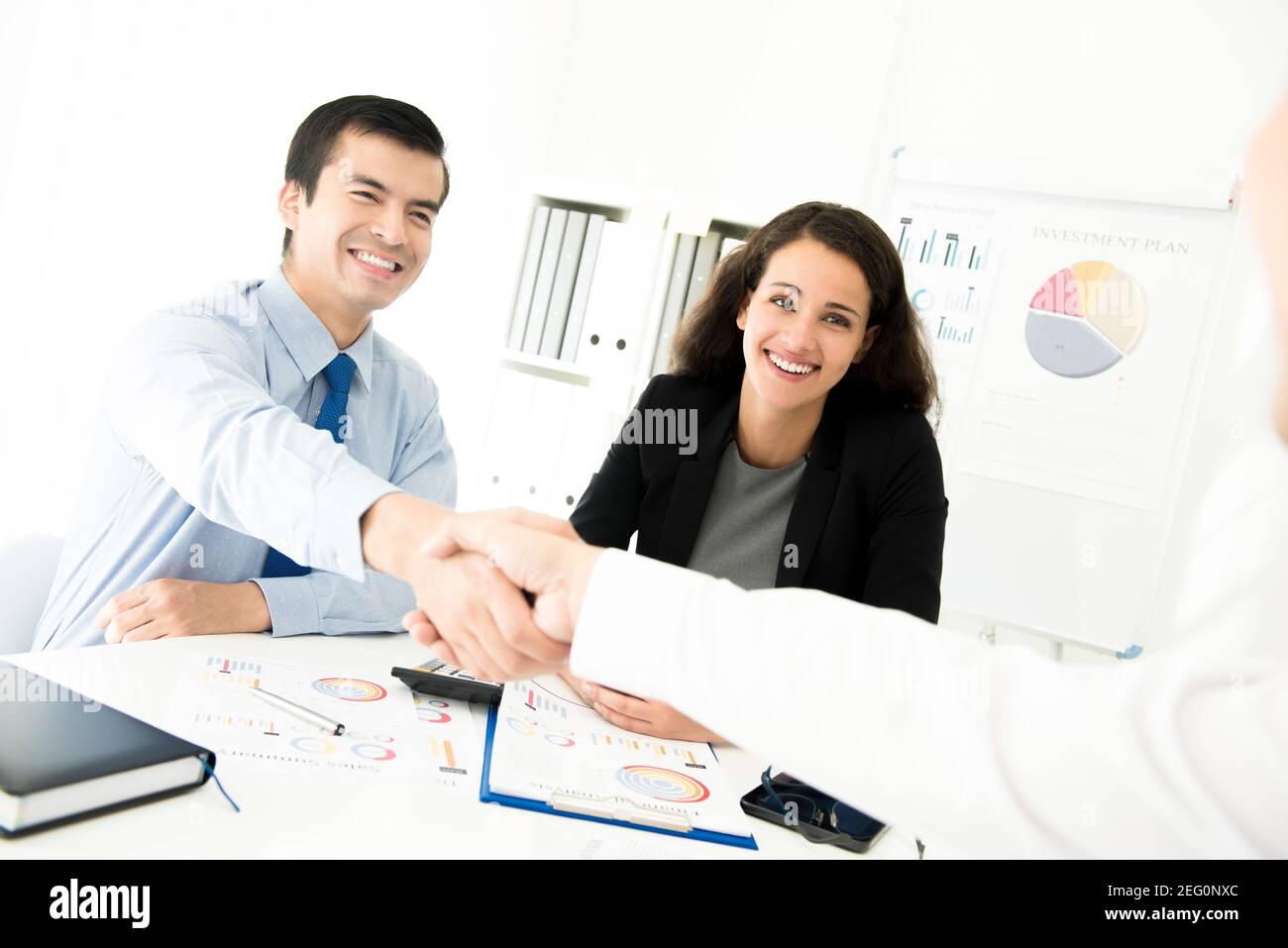 Businessmen making handshake in meeting room Stock Photo