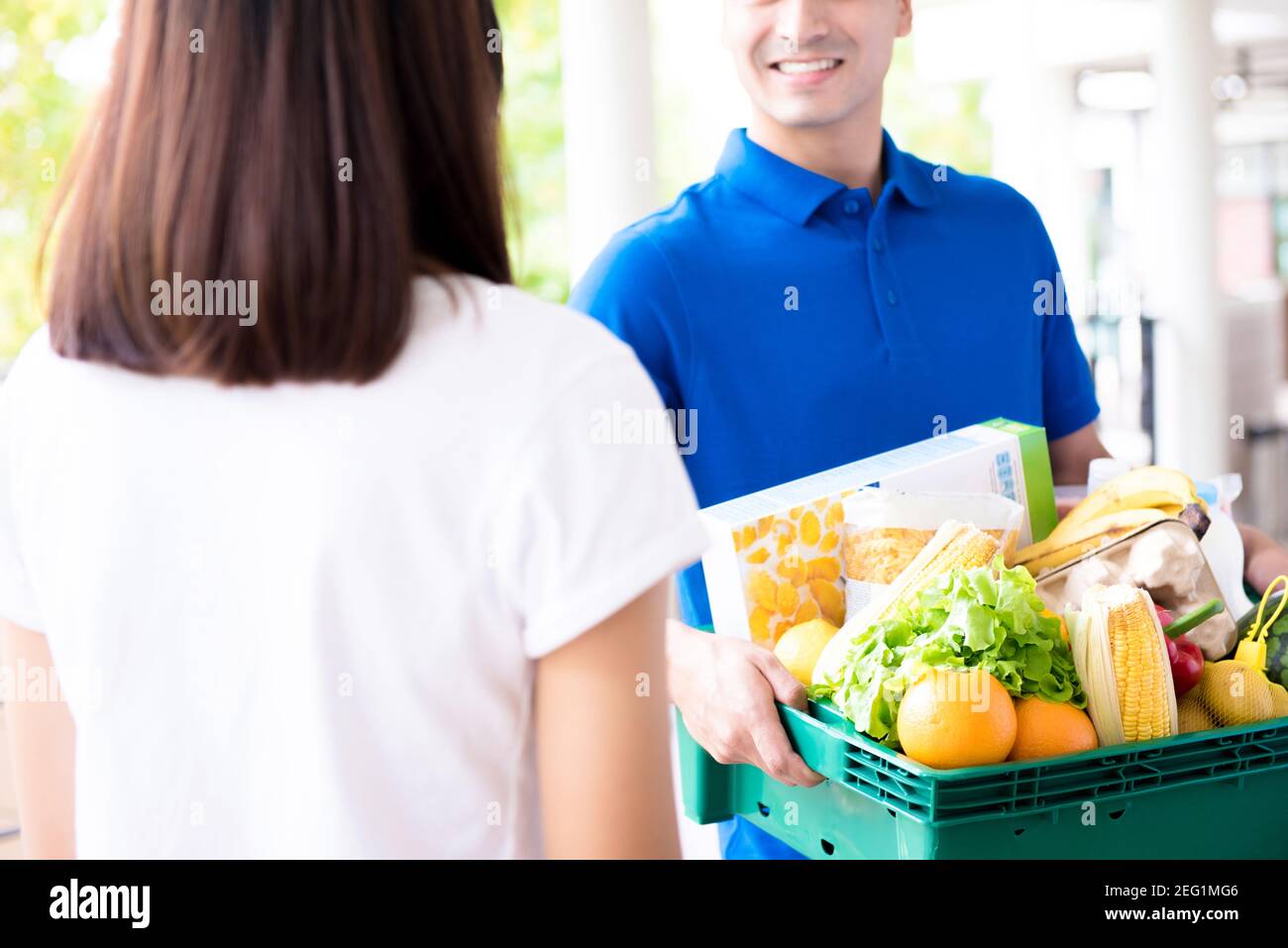 Delivery man delivering food to a woman - online grocery shopping service concept Stock Photo