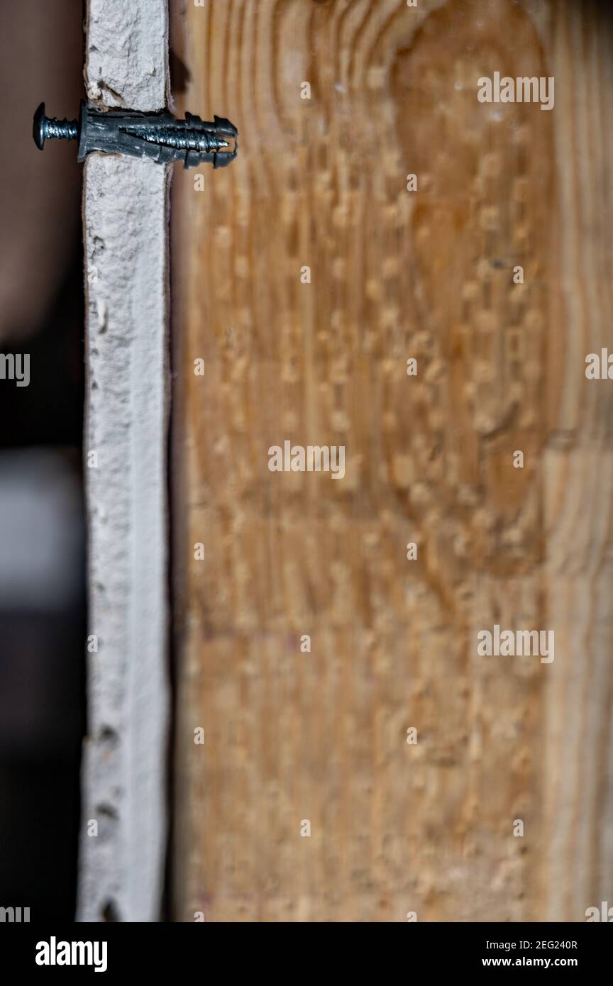 Side view of a drywall mount anchor and screw for hanging objects on