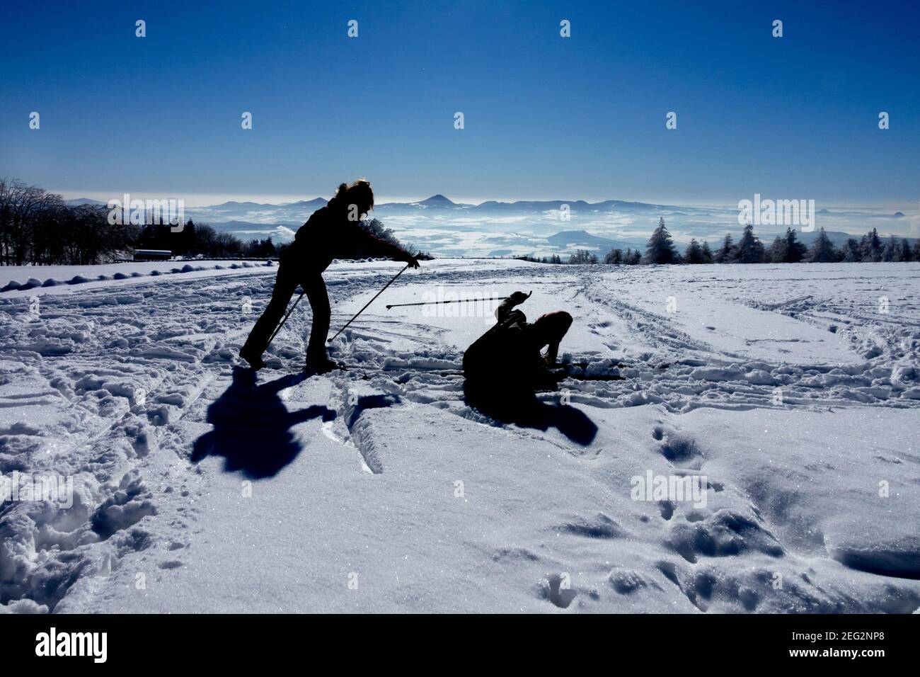 Silhouettes of a pair of skiers enjoying a nice sunny day in a snowy landscape Stock Photo