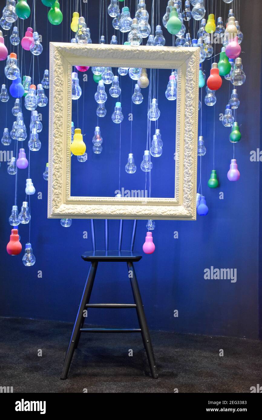 Multi-colored bulbs and a white frame hanging from the ceiling. Stock Photo