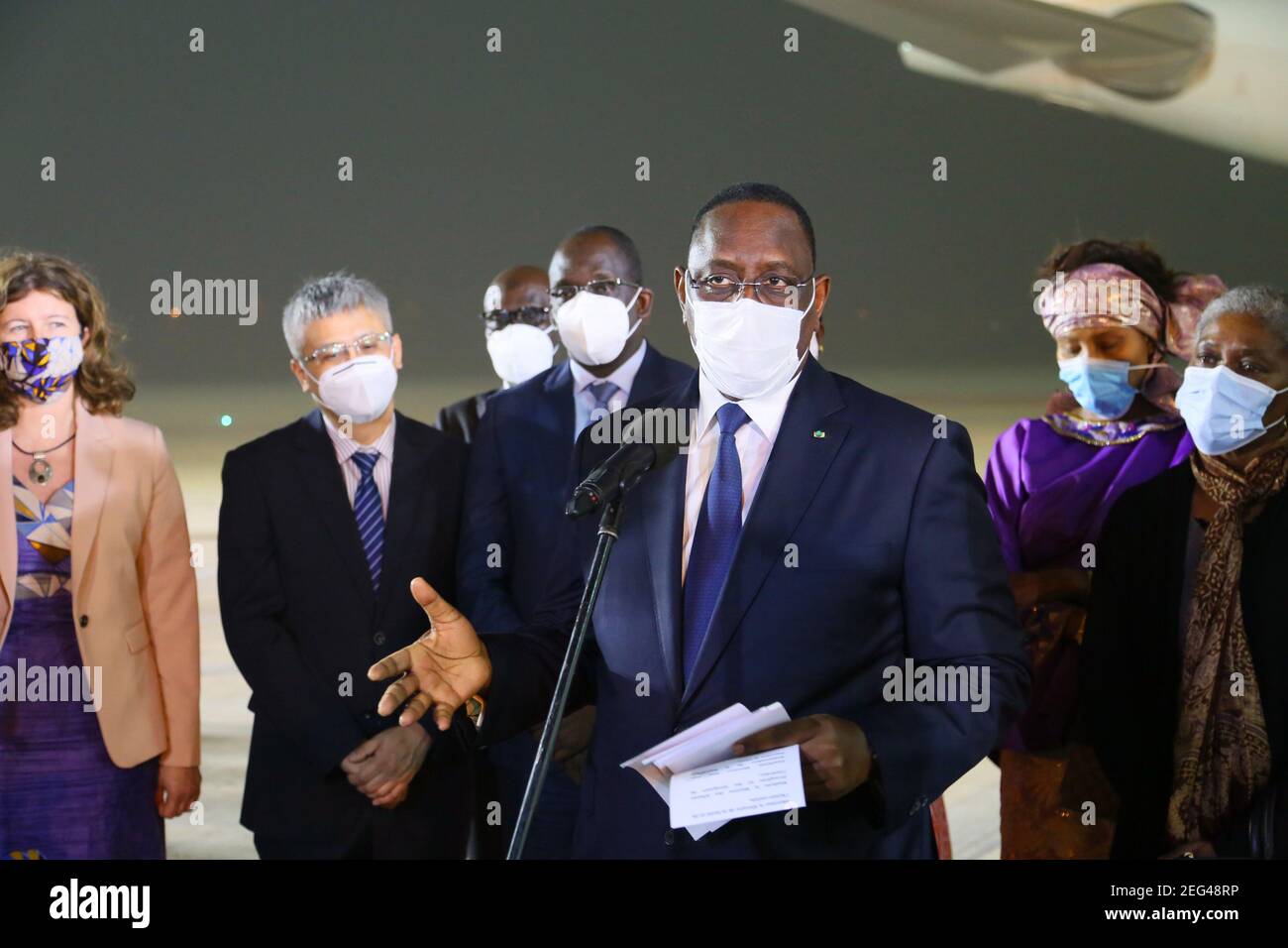 Dakar, Senegal. 17th Feb, 2021. Senegalese President Macky Sall (front) speaks during the delivery ceremony of the first batch of China's Sinopharm COVID-19 vaccine at Blaise Diagne International Airport in Dakar, Senegal, Feb. 17, 2021. Senegal on Wednesday night received the first batch of China's Sinopharm COVID-19 vaccine. Credit: Xing Jianqiao/Xinhua/Alamy Live News Stock Photo