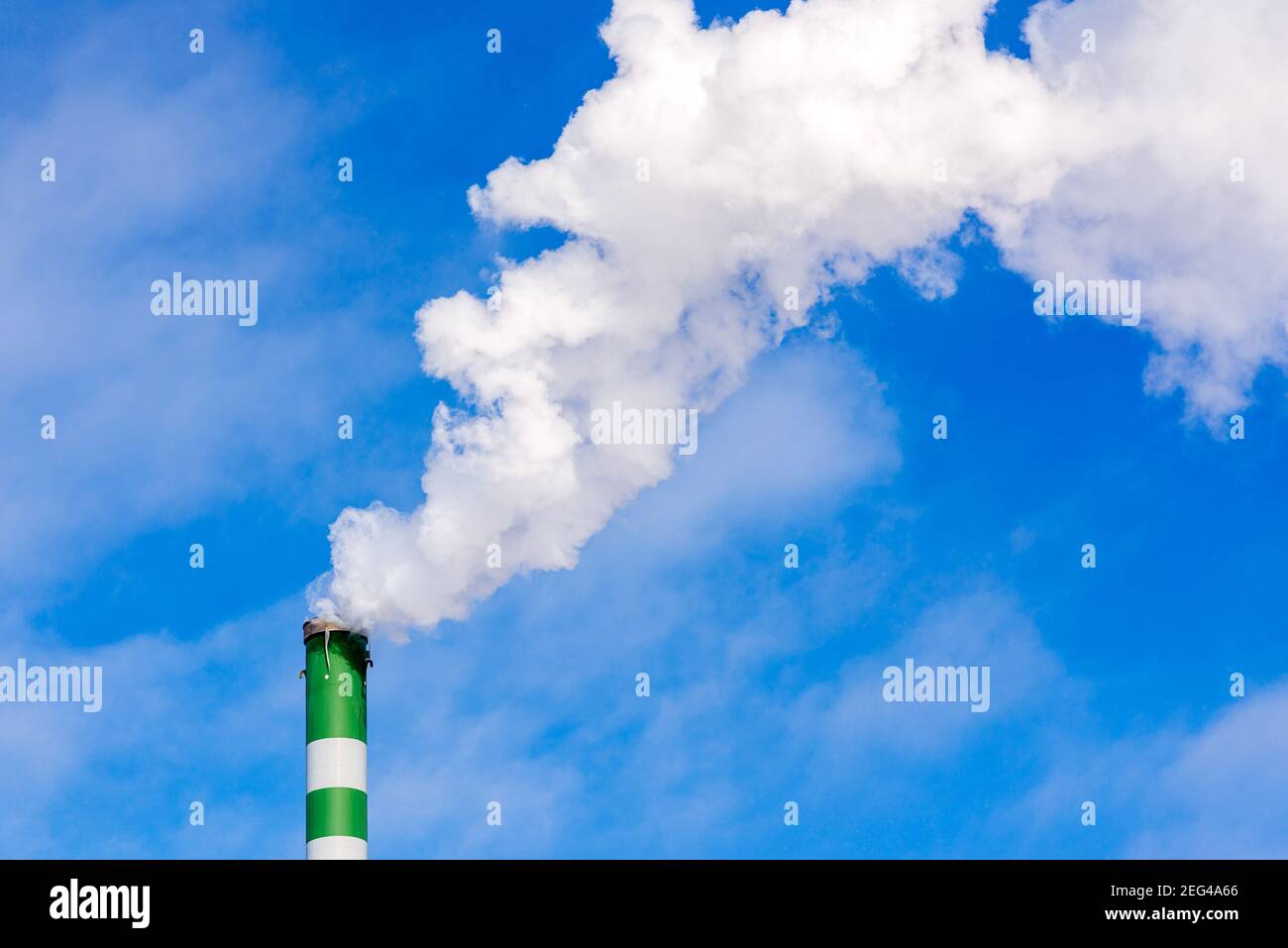 One Industrial smoke pipe from chimney on blue cloudy sky.White smoke