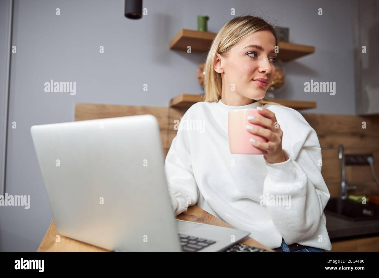 Woman getting distracted from job while drinking tea Stock Photo