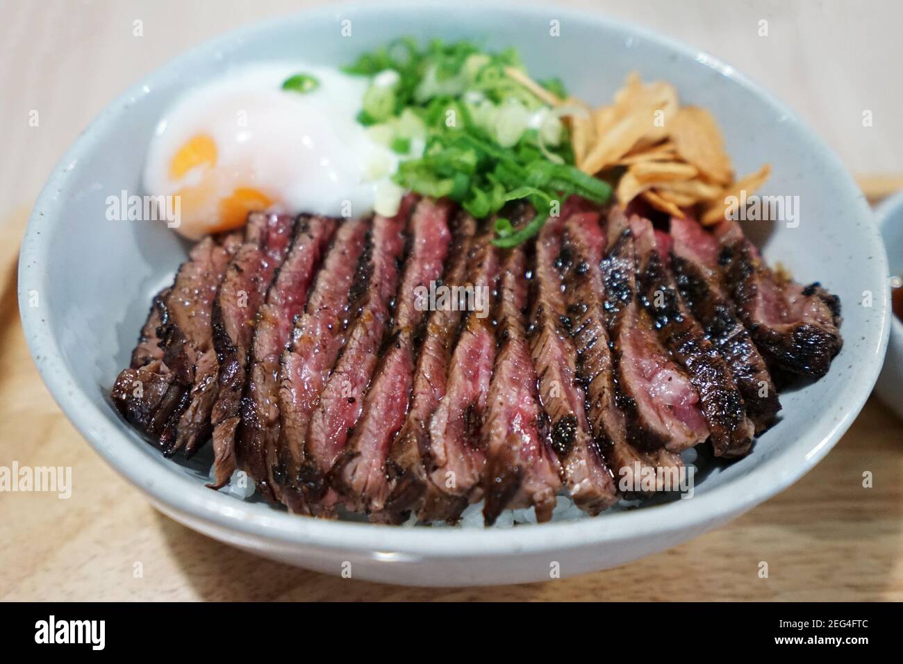 Close up Sliced medium rare Wagyu beef served on rice and topped with poached egg Stock Photo