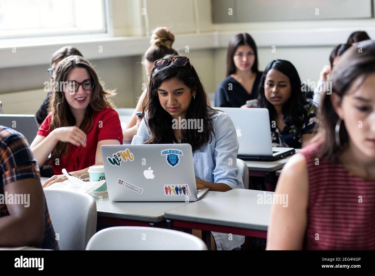 Female college students working on computer in classroom, young adults in further education. Stock Photo