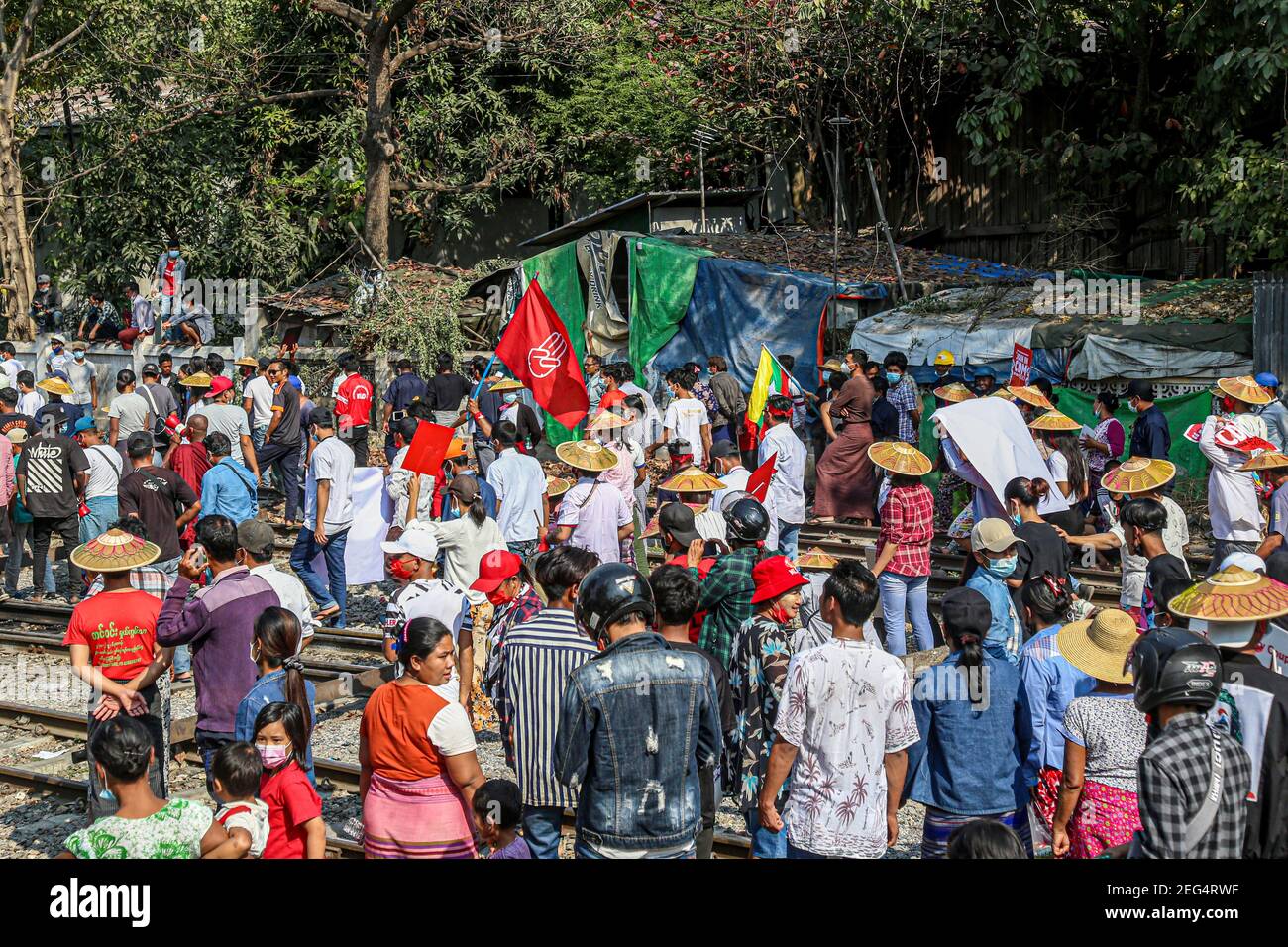 Protesters seen gathered in the middle of the railway during the protest.Anti-military coup protesters occupied train tracks near employee housing at the city's central railway in Myanmar's second-largest city, Mandalay, to protest against the military coup. After several hours police fired 40 real bullets shots toward protesters and sprayed tear gas to disperse the crowd during the 12th day of protest against the military takeover on 1st February 2021. Myanmar's military detained State Counsellor of Myanmar Aung San Suu Kyi on February 01, 2021 and declared a state of emergency while seizing Stock Photo