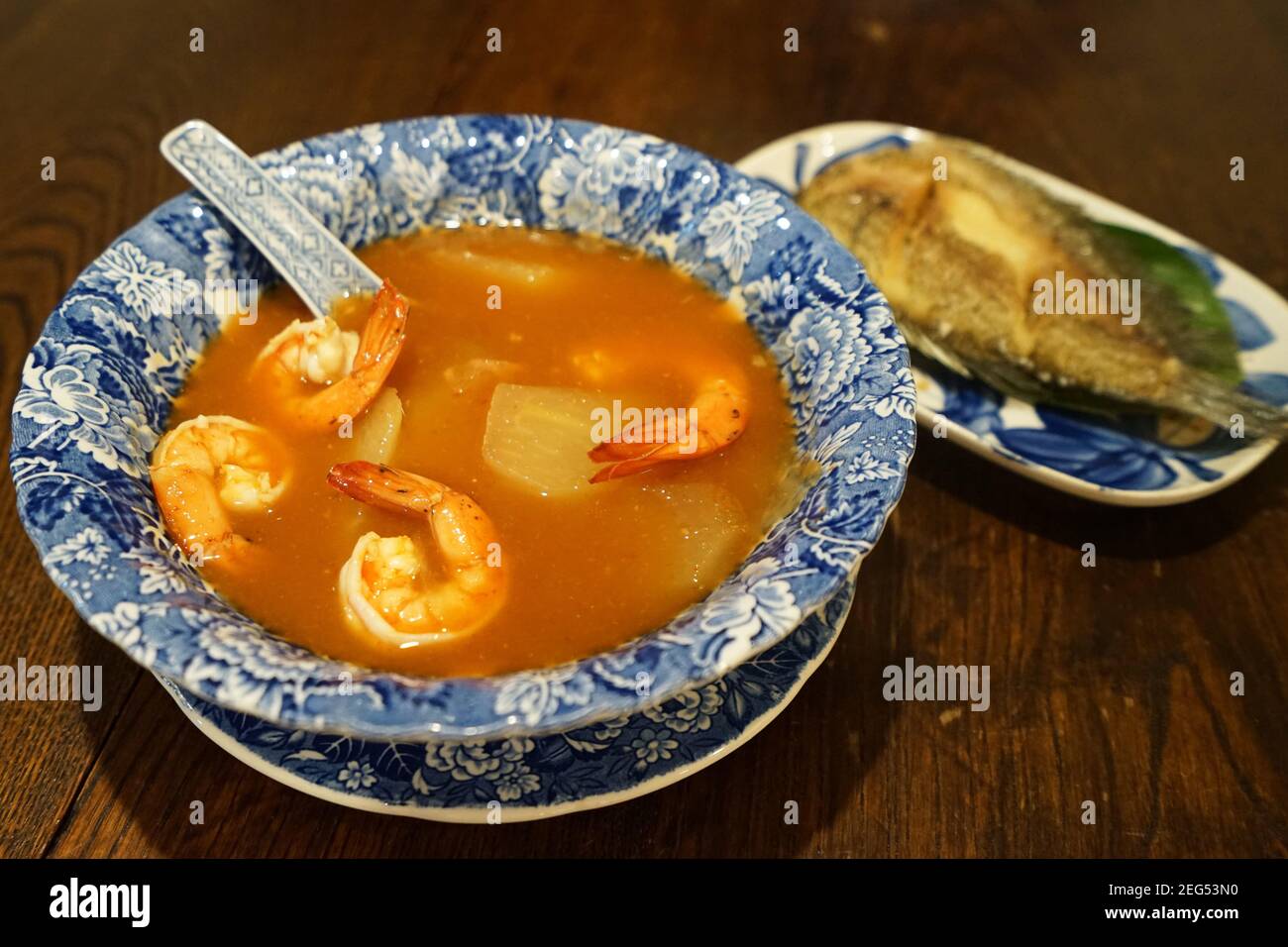 Shrimp sour curry soup served with deep fried Gourami (Gouramy) fish Stock Photo