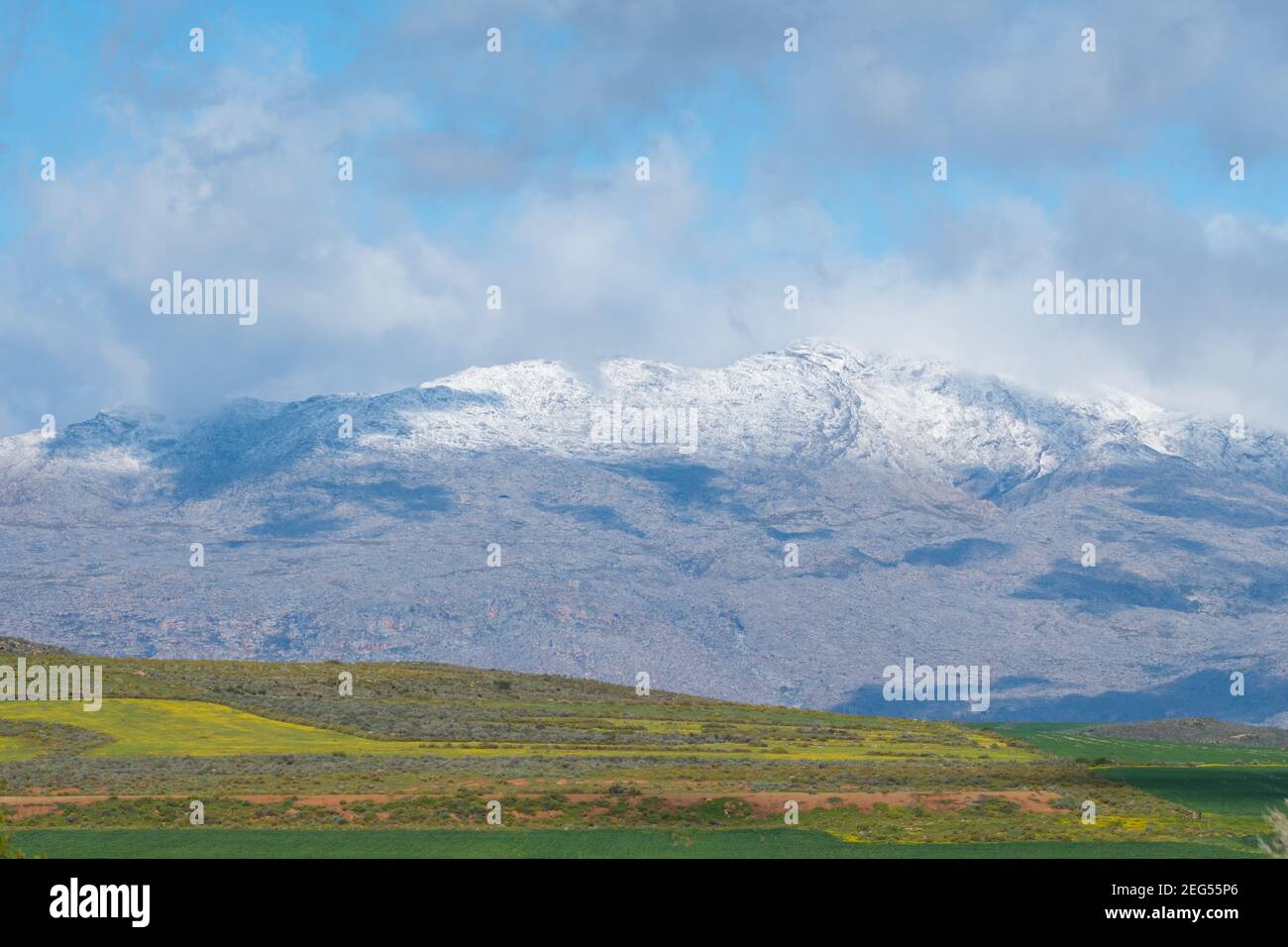 Winter landscape view of snow capped mountains and farmland in the agricultural region of Ceres, Western Cape, South Africa Stock Photo