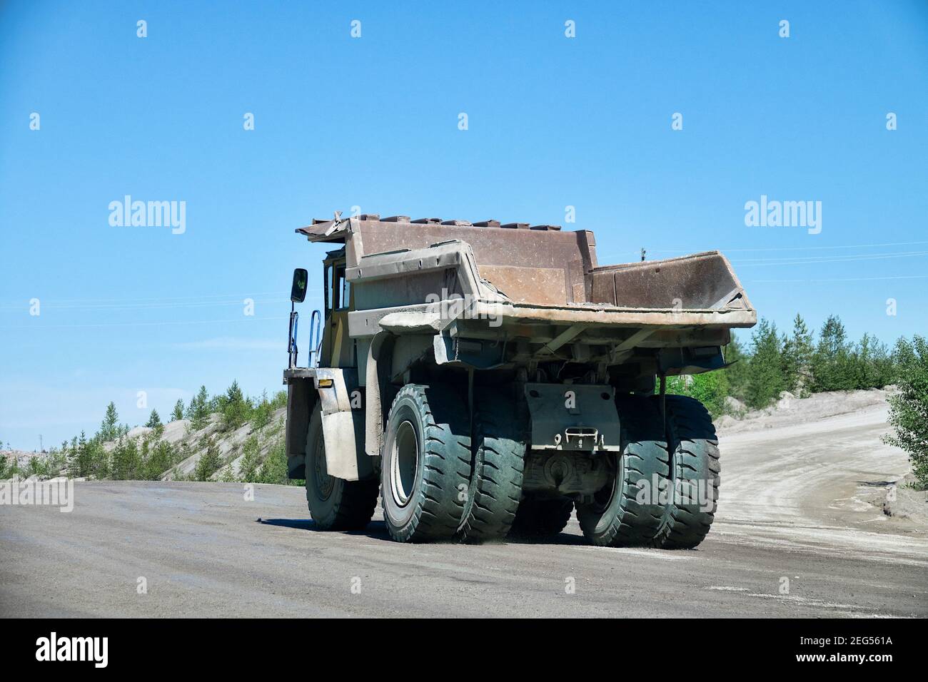 A big dump truck is moving along the highway. In the frame of the