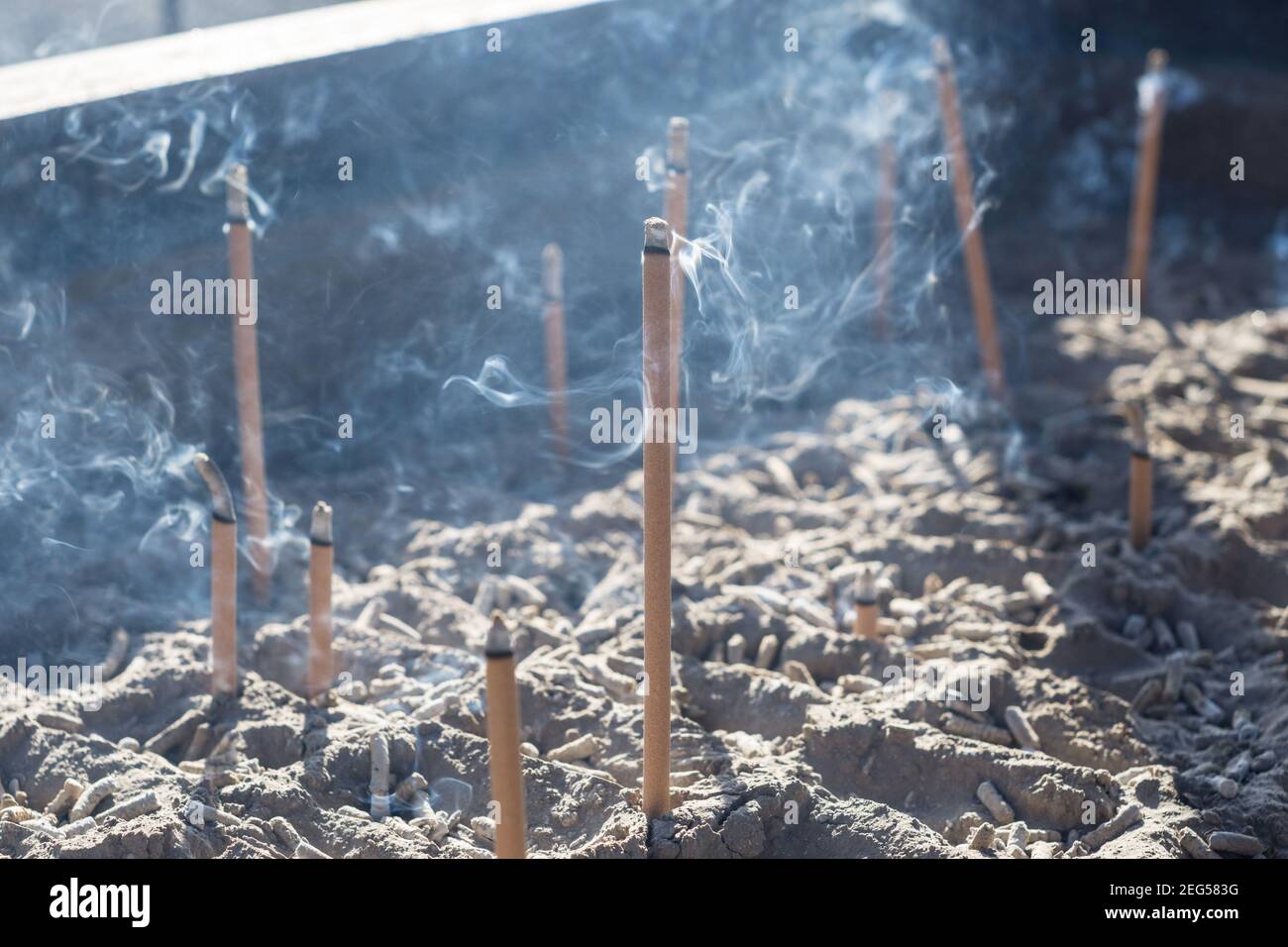 Smoke from burning incense sticks in a large caldron koro burner or