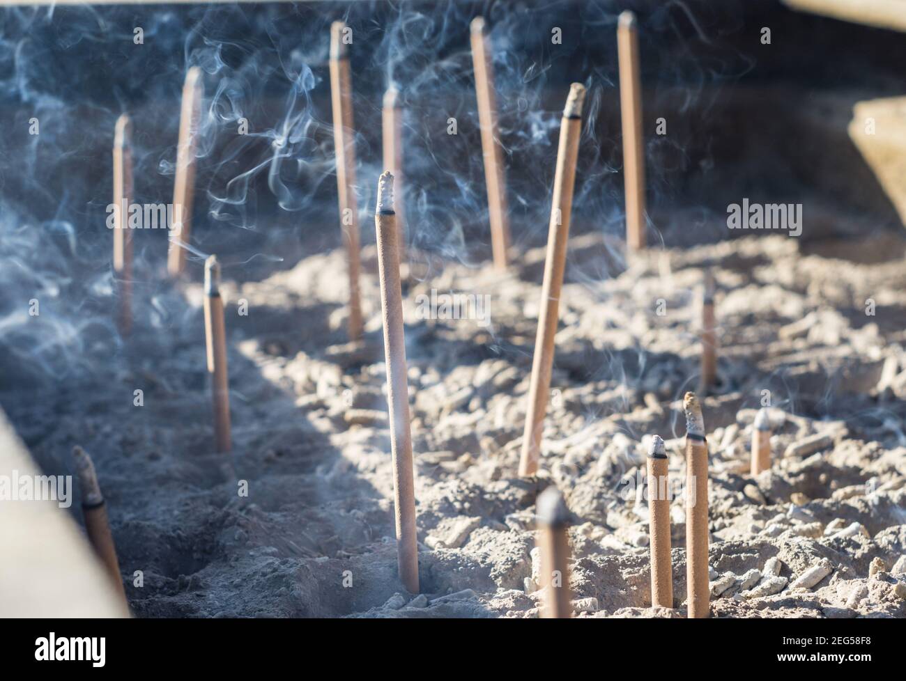 Smoke from burning incense sticks in a large caldron koro burner or