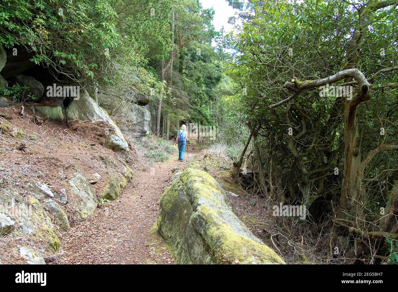 Cragside Northumberland UK rocky area blonde girl walking with backpack ...