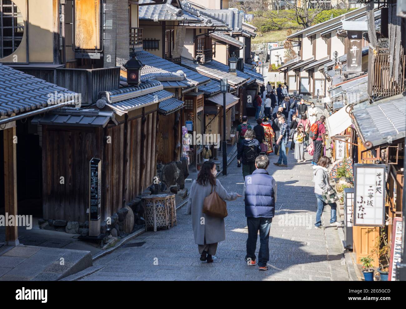 Visitors walking along Ninenzaka, or Ninen-zaka, a preserved pedestrian shopping street in the Higashiyama area of Kyoto, Japan Stock Photo