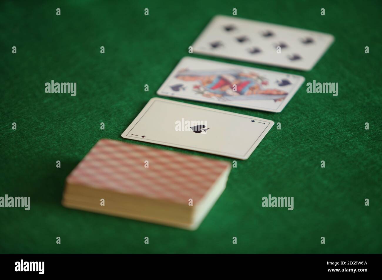 deck of playing cards on a green gaming table Stock Photo