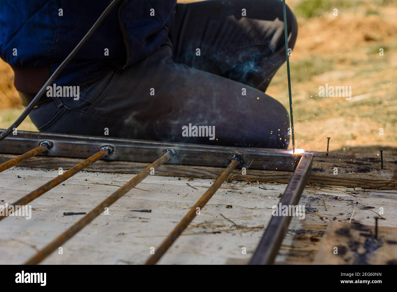 Welding a metal profile at home, a man welds metal to design an aviary for a dog.2020 Stock Photo