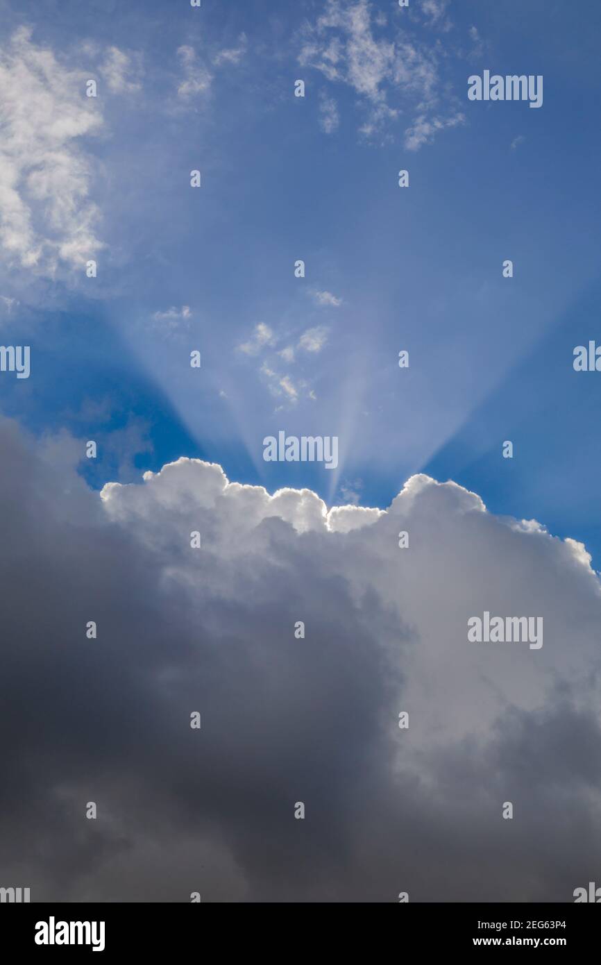 Rays of sunlight breaking above clouds Stock Photo