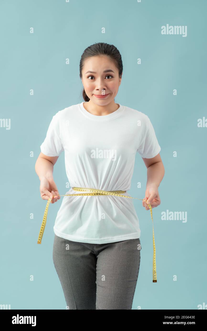 Women healthy body care weight control measuring waist fat using tape measure or measuring tape. Stock Photo