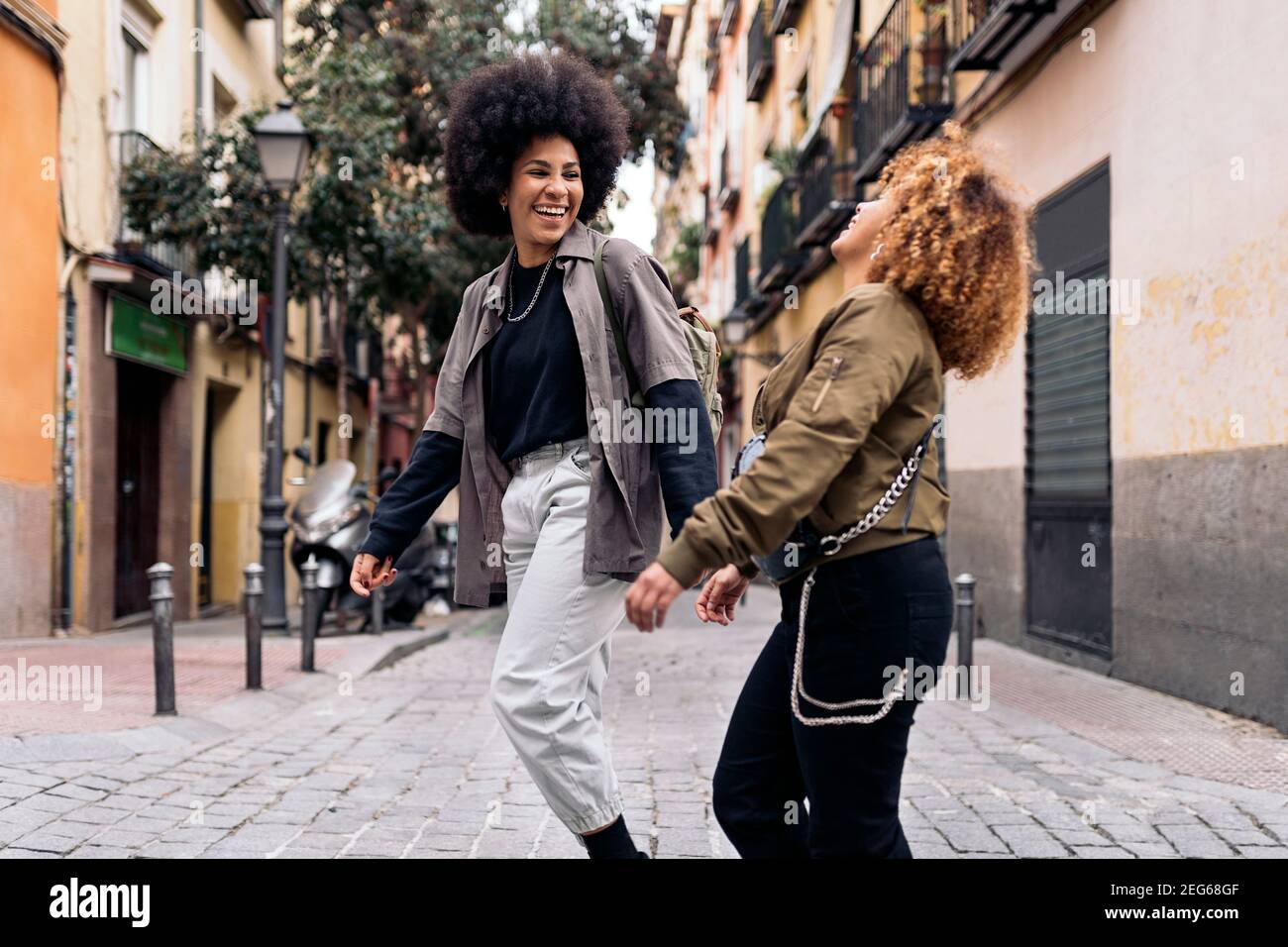 Stock photo of casual happy afro girls laughing and walking in the city ...