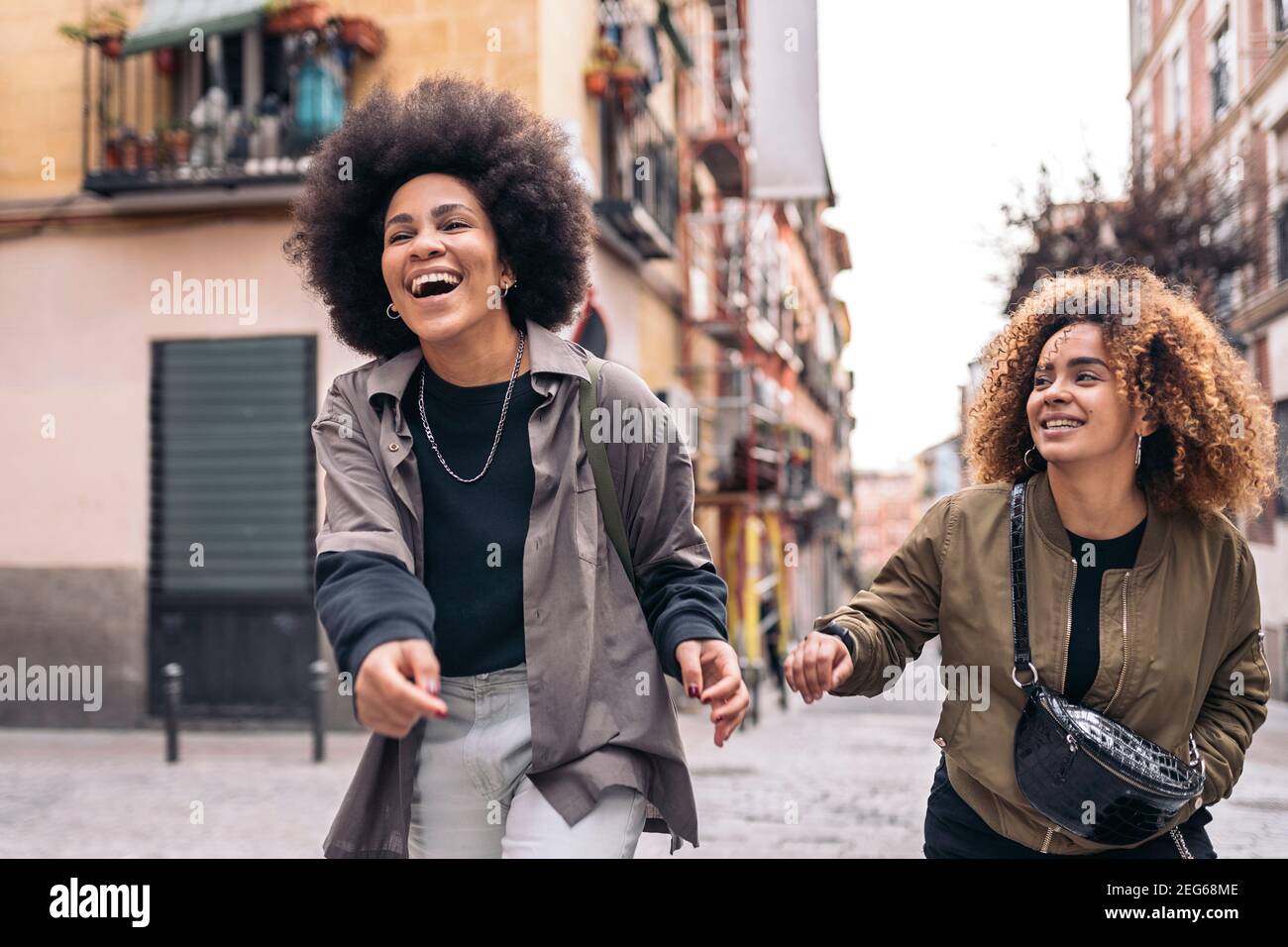 Stock photo of casual happy afro girls laughing and walking in the city ...