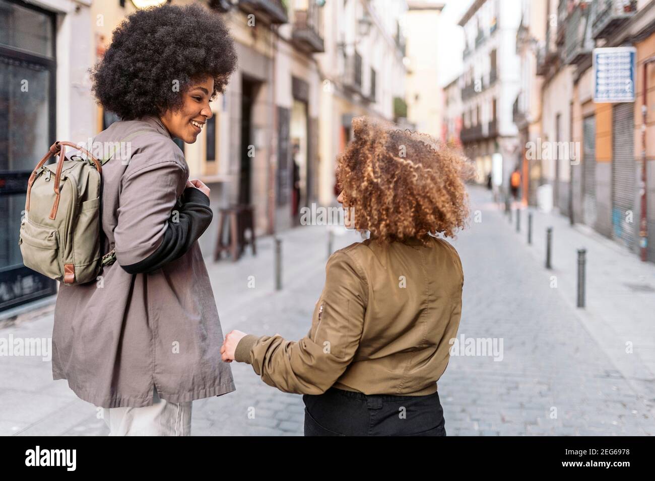 Stock photo of casual happy afro girls laughing and walking in the city ...