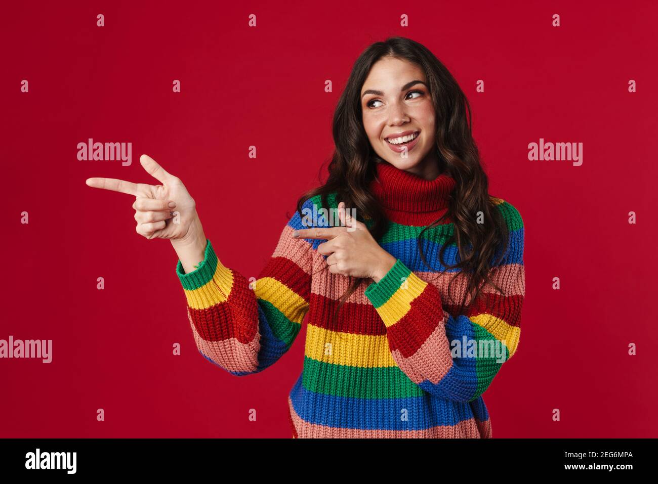 Joyful beautiful brunette girl smiling and pointing fingers aside ...