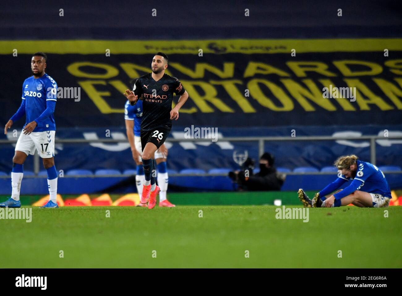Liverpool, United Kingdom, 17th February 2021. Pictured left to right, Everton’s Alex Iwobi looks-on as Manchester City's Riyad Mahrez celebrates scoring his side's third goal of the game as Everton’s Tom Davies reacts. Credit: Anthony Devlin/Alamy Live News Stock Photo