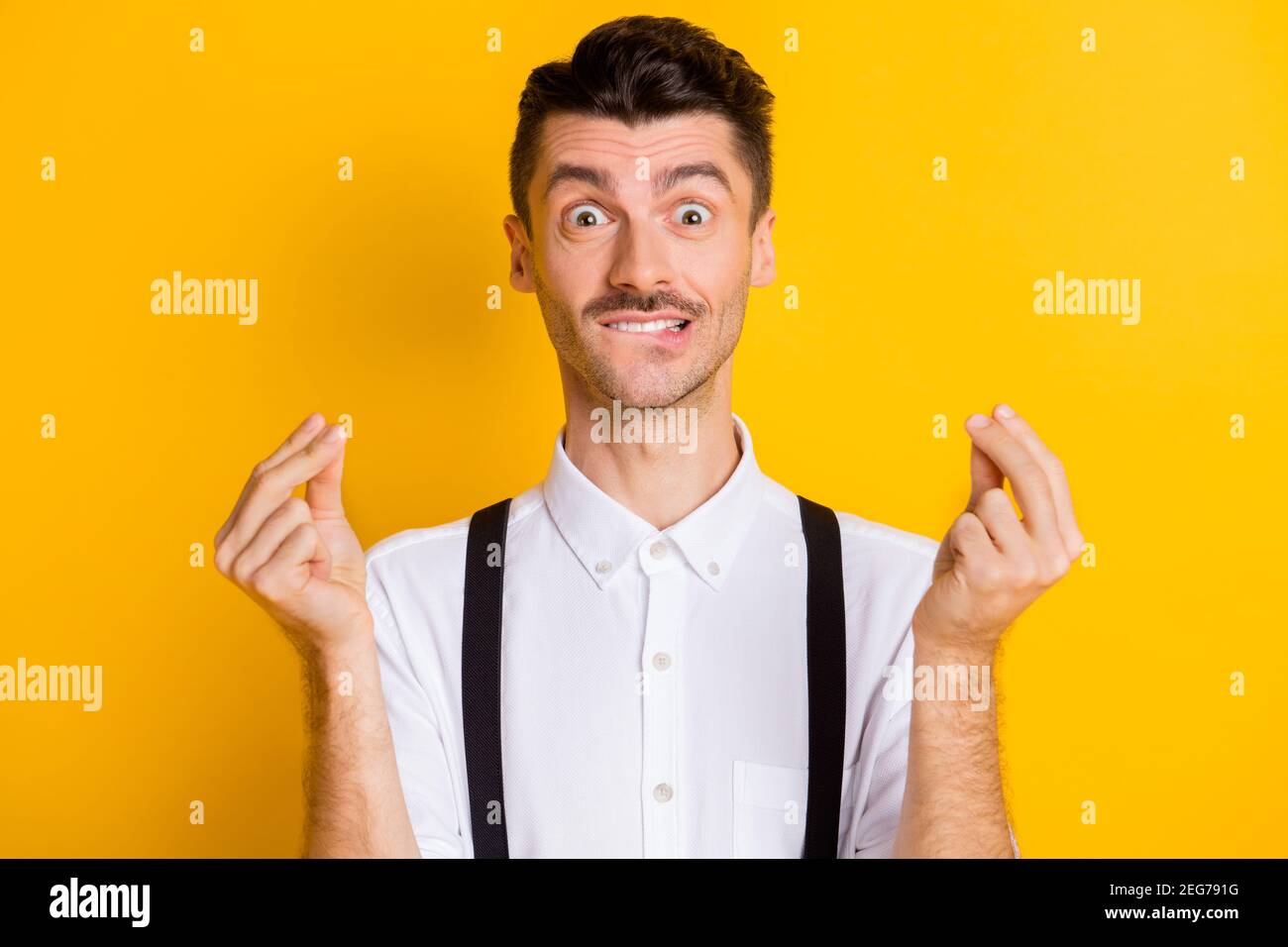 Portrait of funny attractive guy wearing white shirt showing money sign ...