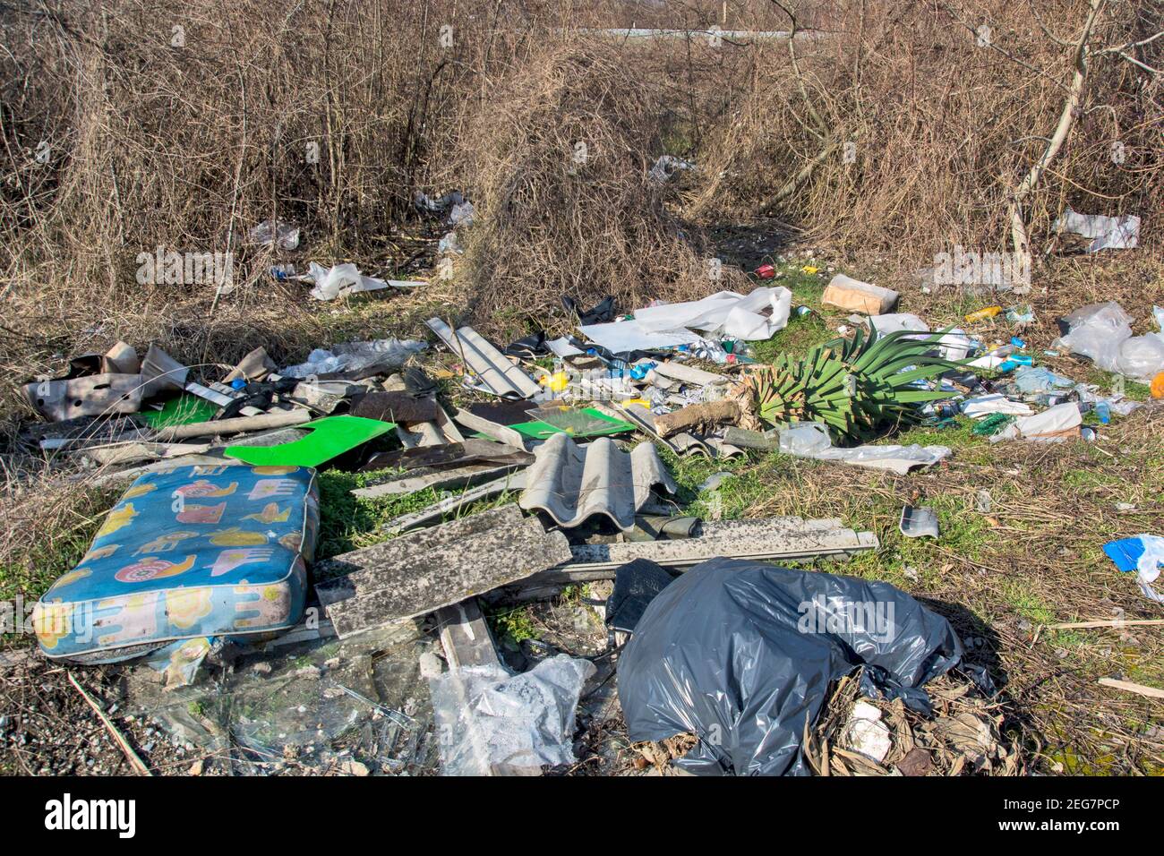 An ugly wild garbage dump in an urban neighborhood. Irresponsible