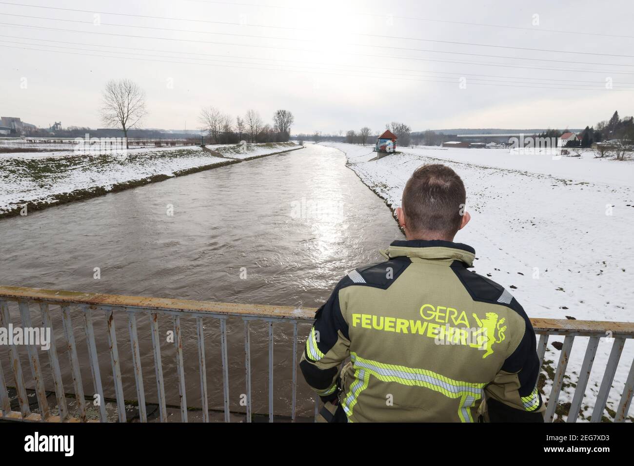 Gera, Germany. 18th Feb, 2021. A firefighter monitors the rapidly rising water level of the White Elster. Due to the thaw, the danger of flooding will also increase in the next few days. Credit: Bodo Schackow/dpa-Zentralbild/dpa/Alamy Live News Stock Photo