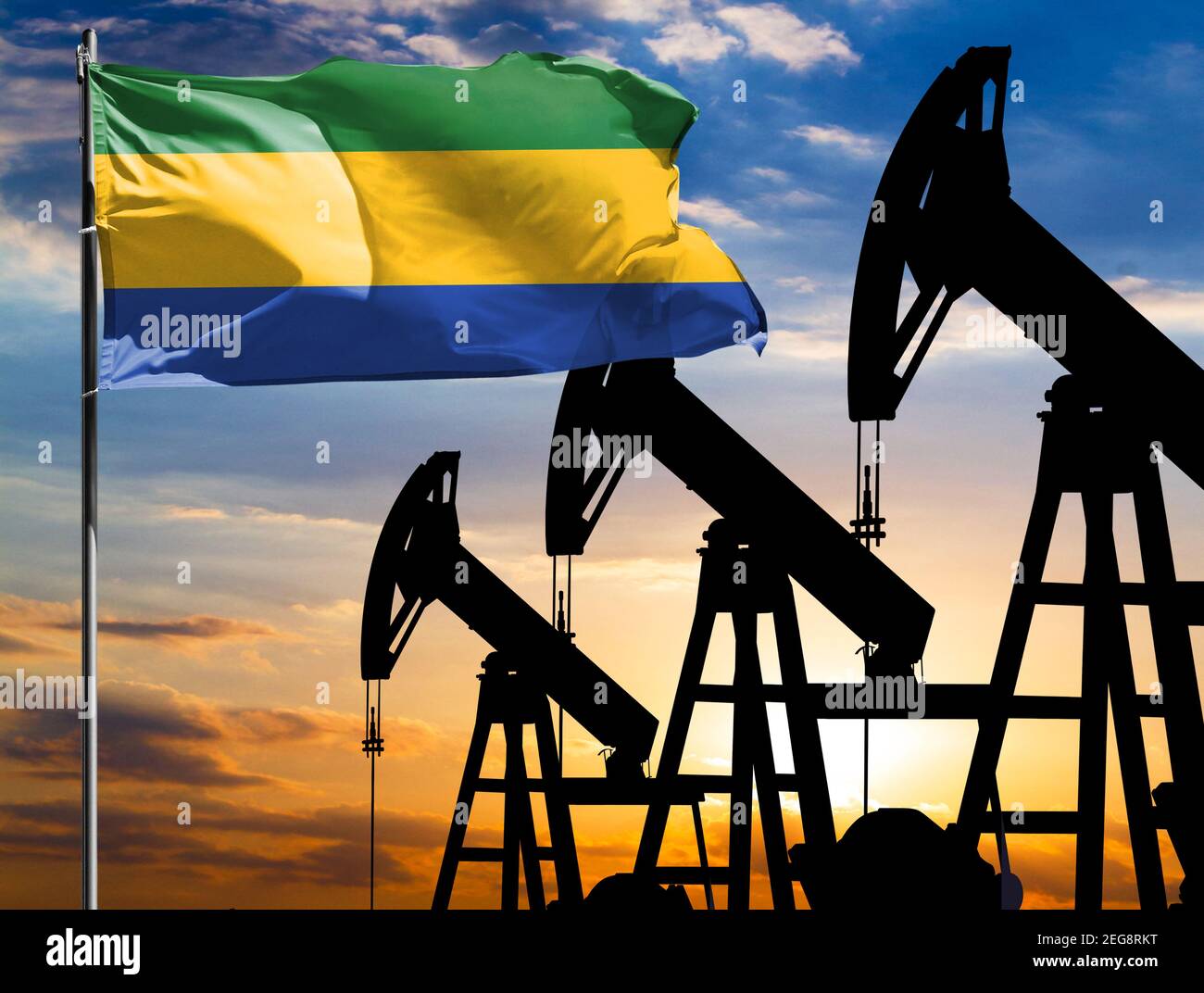Oil rigs against the backdrop of the colorful sky and a flagpole with ...
