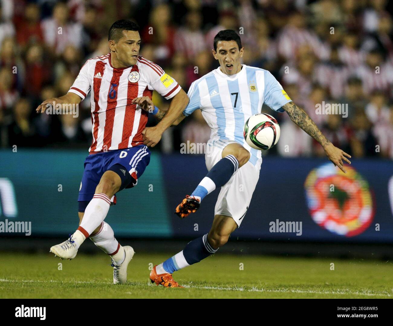 Argentina's Angel Di Maria (R) kicks the ball past Paraguay's Miguel Samudio during their 2018 World Cup qualifying soccer match at the Defensores del Chaco stadium in Asuncion, Paraguay, October 13, 2015.     REUTERS/Jorge Adorno    Picture Supplied by Action Images Stock Photo