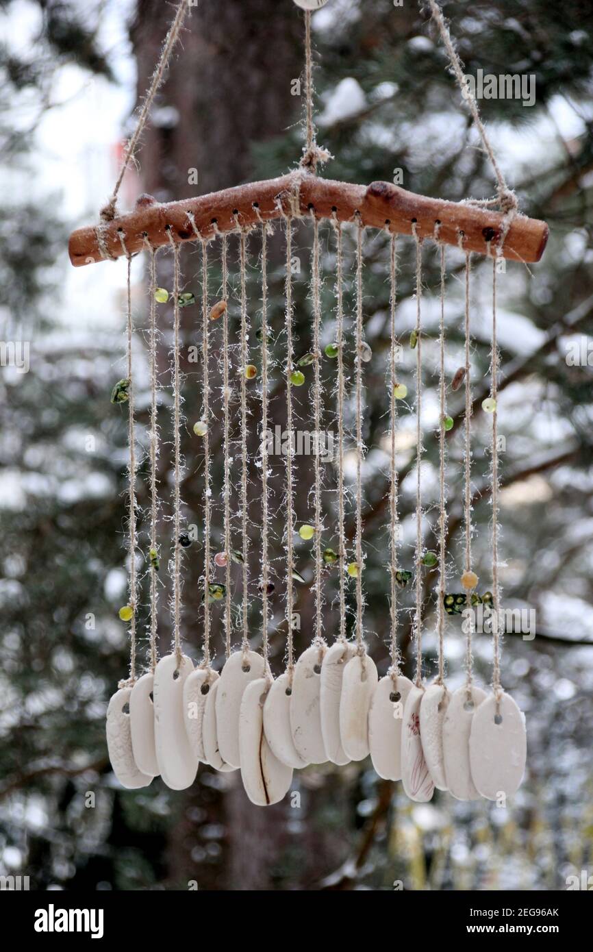 Hand made wind chimes hanging on a string with depth of field effect.  Ceramic wind chime hanging outside, selective focus, Wind bells from clay  Stock Photo - Alamy