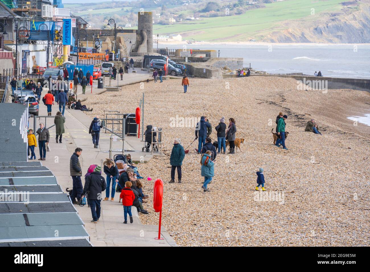 Lyme Regis, Dorset, UK. 18th Feb, 2021. UK Weather: People make the best of the sunny spells at Lyme Regis at half term. The popular seaside resort is much quieter than normal during the school holidays as the third UK lockdown continues. Credit: Celia McMahon/Alamy Live News Stock Photo