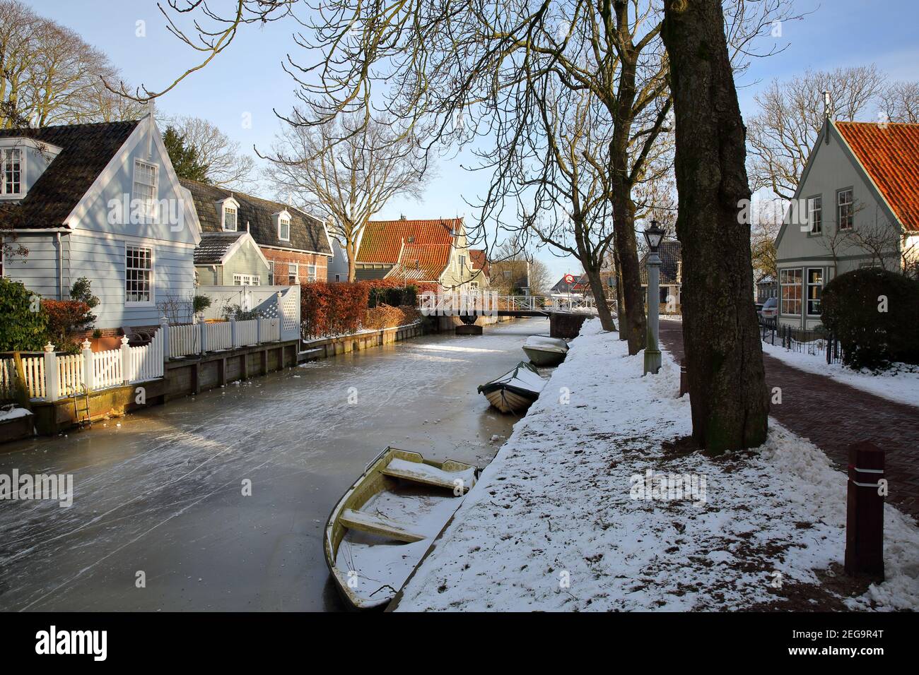Winter snow and  frozen canals in Broek in Waterland, a small town with traditional old and painted wooden houses, North Holland, Netherlands. Stock Photo