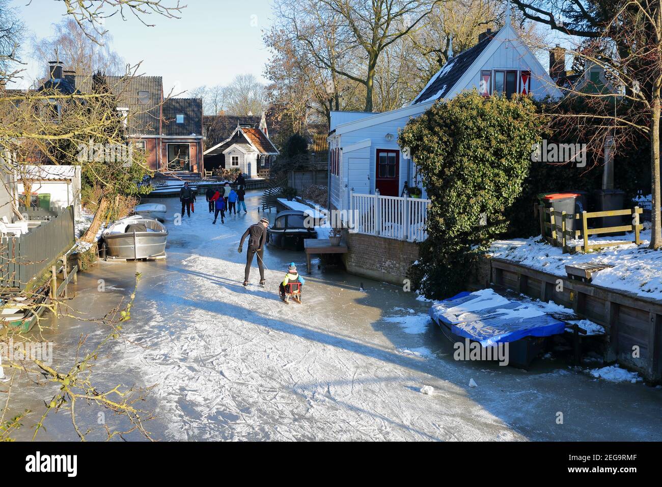 BROEK IN WATERLAND, NETHERLANDS - FEBRUARY 13, 2020: Winter snow and people ice skating on frozen canals in Broek in Waterland Stock Photo