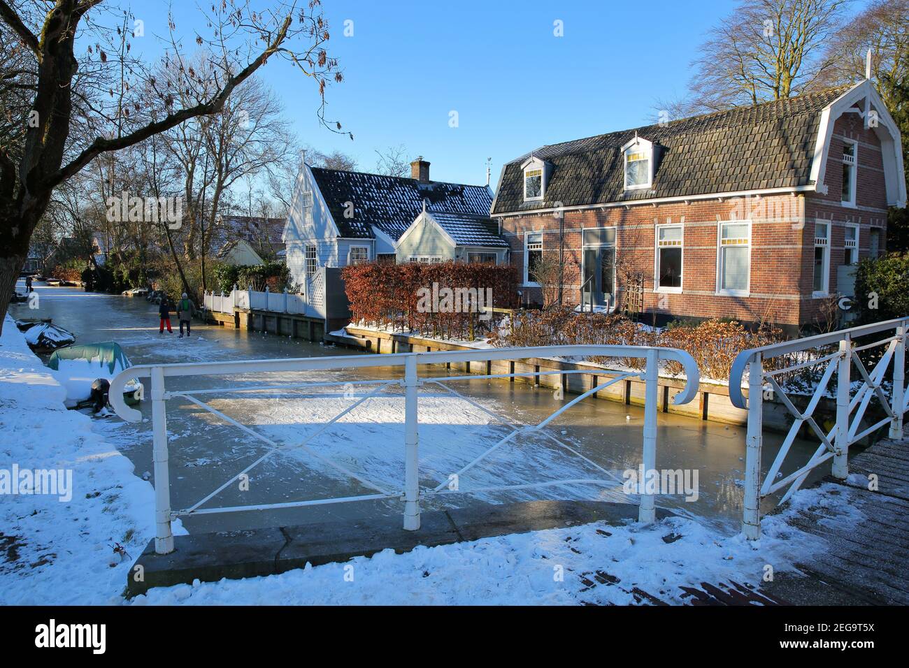 Winter snow and  frozen canals in Broek in Waterland, a small town with traditional old and painted wooden houses, North Holland, Netherlands. Stock Photo