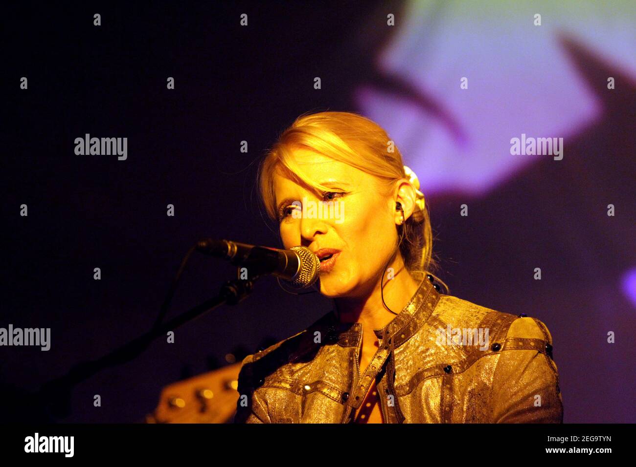 Female singer performing live at an indoor concert Stock Photo