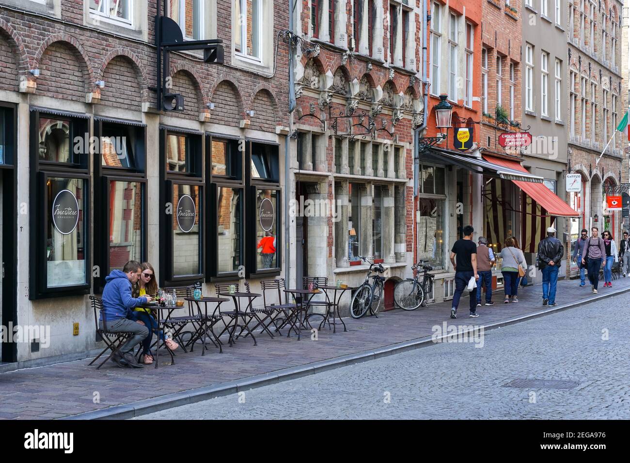 People sitting outside restaurant in Bruges, Belgium Stock Photo