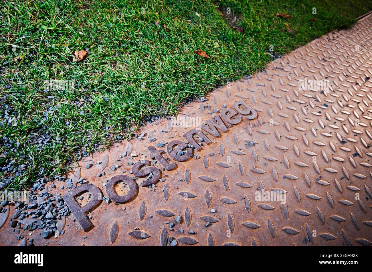 Detailed view of the Border post way at the Berlin Wall (1961-1989) Memorial, illustrated with steel pavement slabs next to a green, sharply delimited. Stock Photo