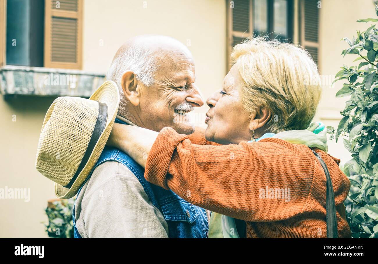 Happy senior retired couple having fun kissing outdoors at travel vacation - Love concept of joyful elderly and retirement lifestyle Stock Photo