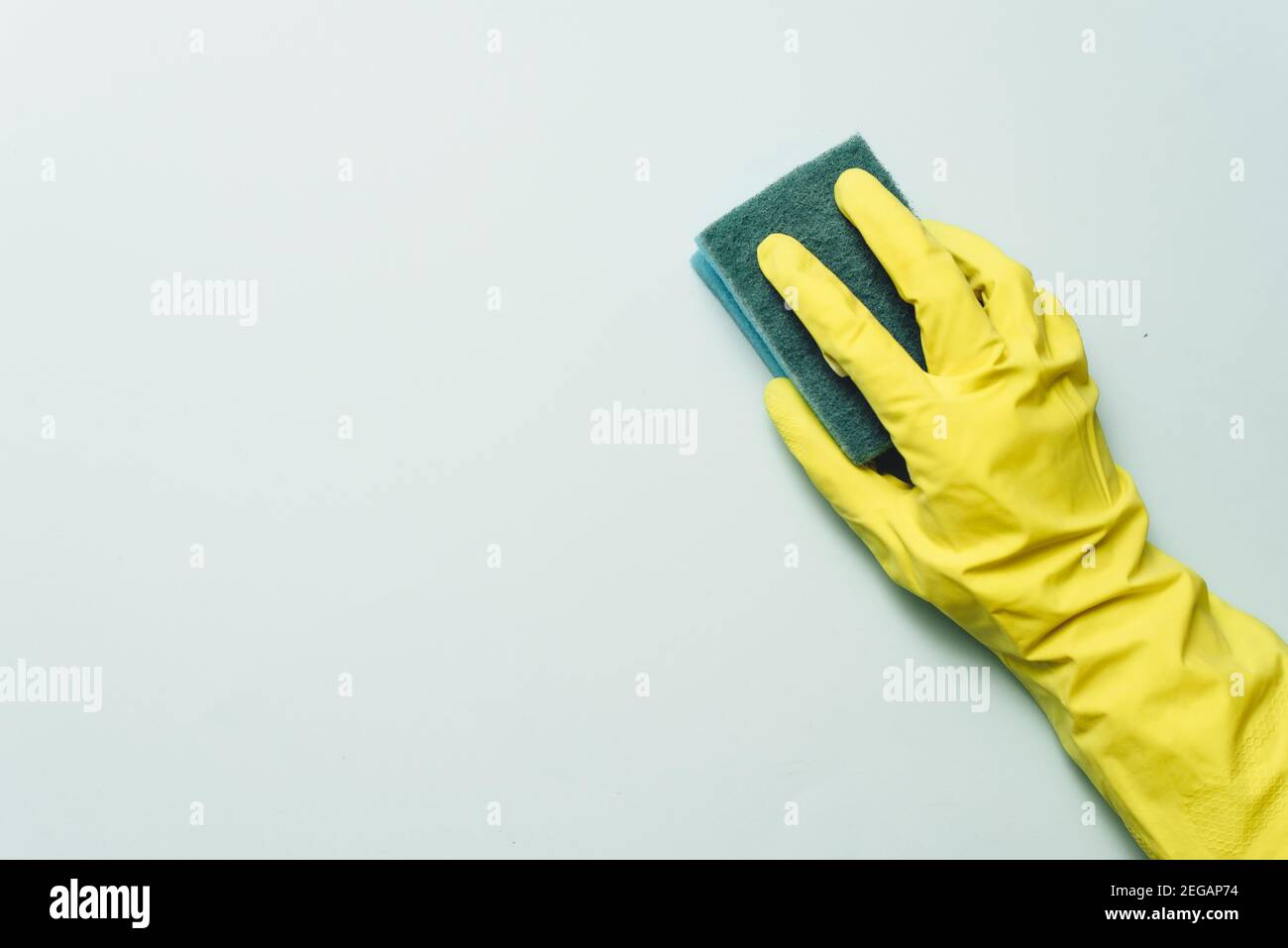yellow rubber glove is holding sponge on the white background. yellow ...