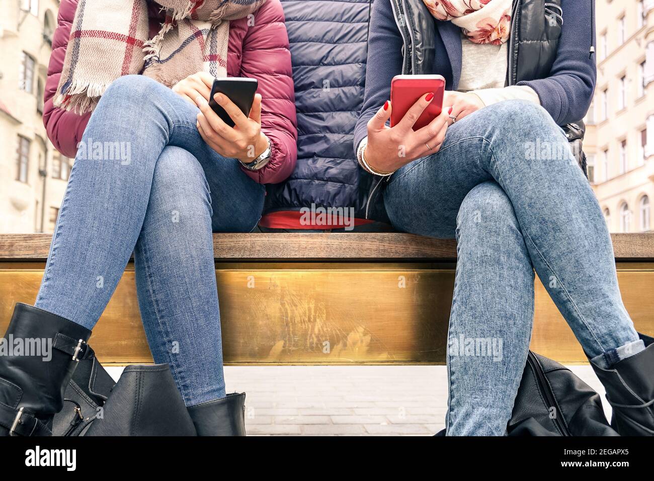 Close up of couple of girlfriends in disinterest moment with mobile smart phones - Concept of relationship apathy sadness and isolation Stock Photo
