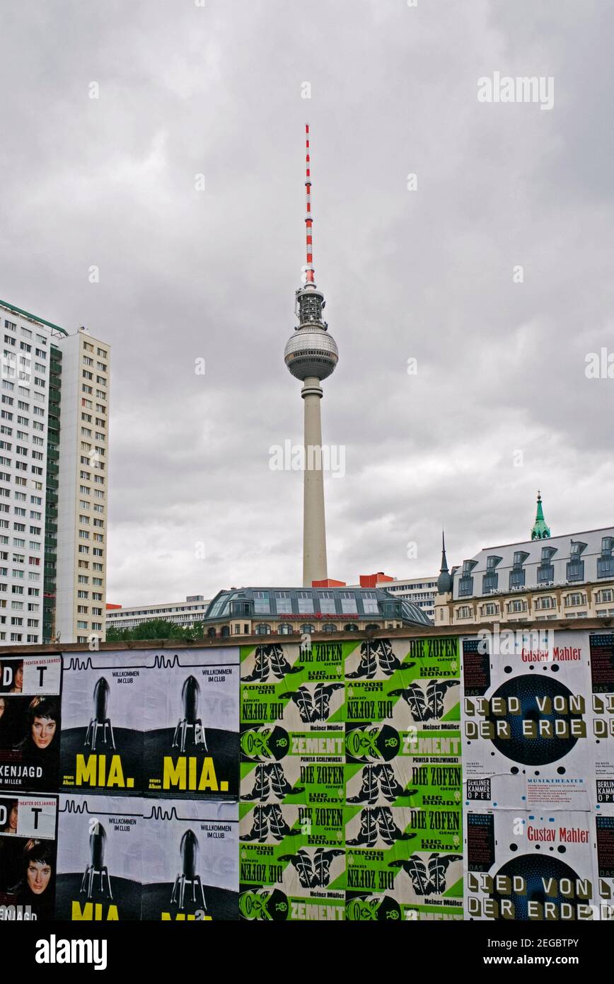 tv tower (fernsehturm) and concert posters on hoarding in Berlin, Germany Stock Photo