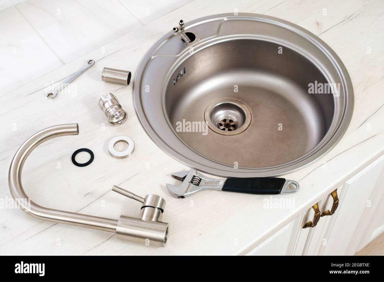 New faucet and tools for installing into the kitchen sink Stock Photo
